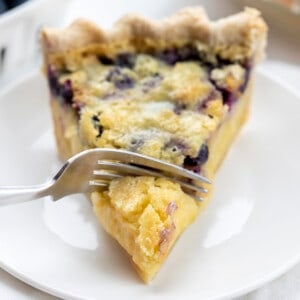 Fork Taking a Bite of Blueberry Buttermilk Pie. Dessert, Baking, Pie, Pie Crust, Best Pie Crust, Buttermilk Pie, Blueberry Pie, Christmas Dessert, Summer Dessert, Old Fashioned Dessert, i am baker, iambaker