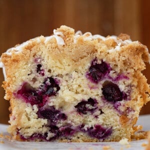 Loaf of Blueberry Lemon Bread Close up on a Cutting Board with Pieces Removed so The Inside Texture is Showing.