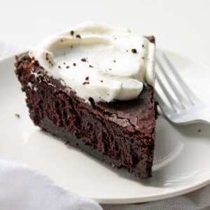 Piece of Brownie Pie on a White Plate with Whipped Cream.