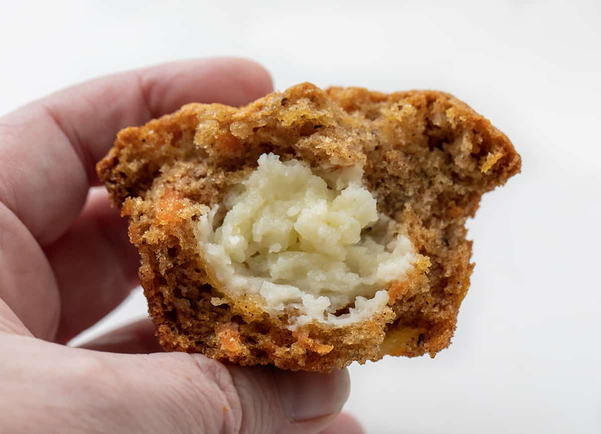 Hand Holding Cream Cheese Filled Carrot Cake Cupcakes.