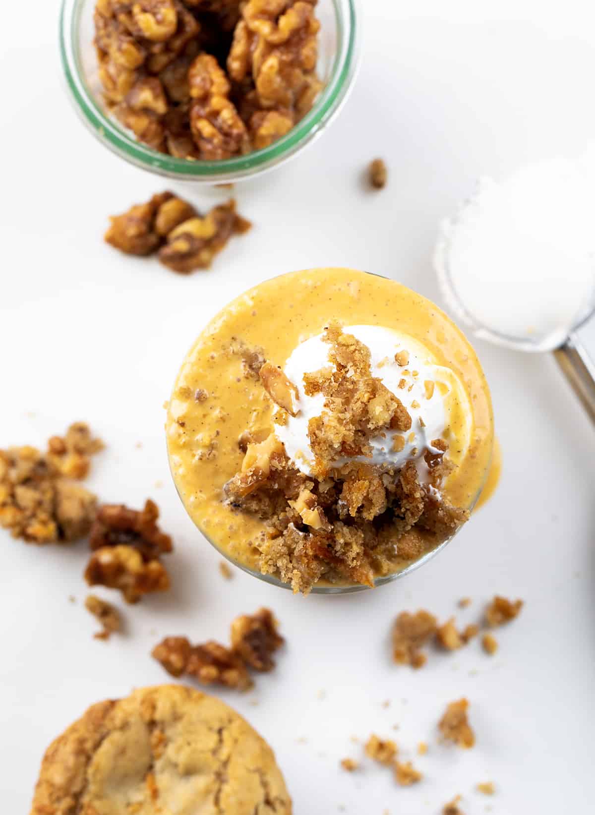 Glass of Carrot Cake Milkshake with Whipped Cream and Crumbled Carrot Cake on Top. from Overhead Looking Down Into Glass.