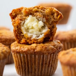 Cream Cheese Filled Carrot Cake Cupcakes Stacked and Surrounded by More Cupcakes.