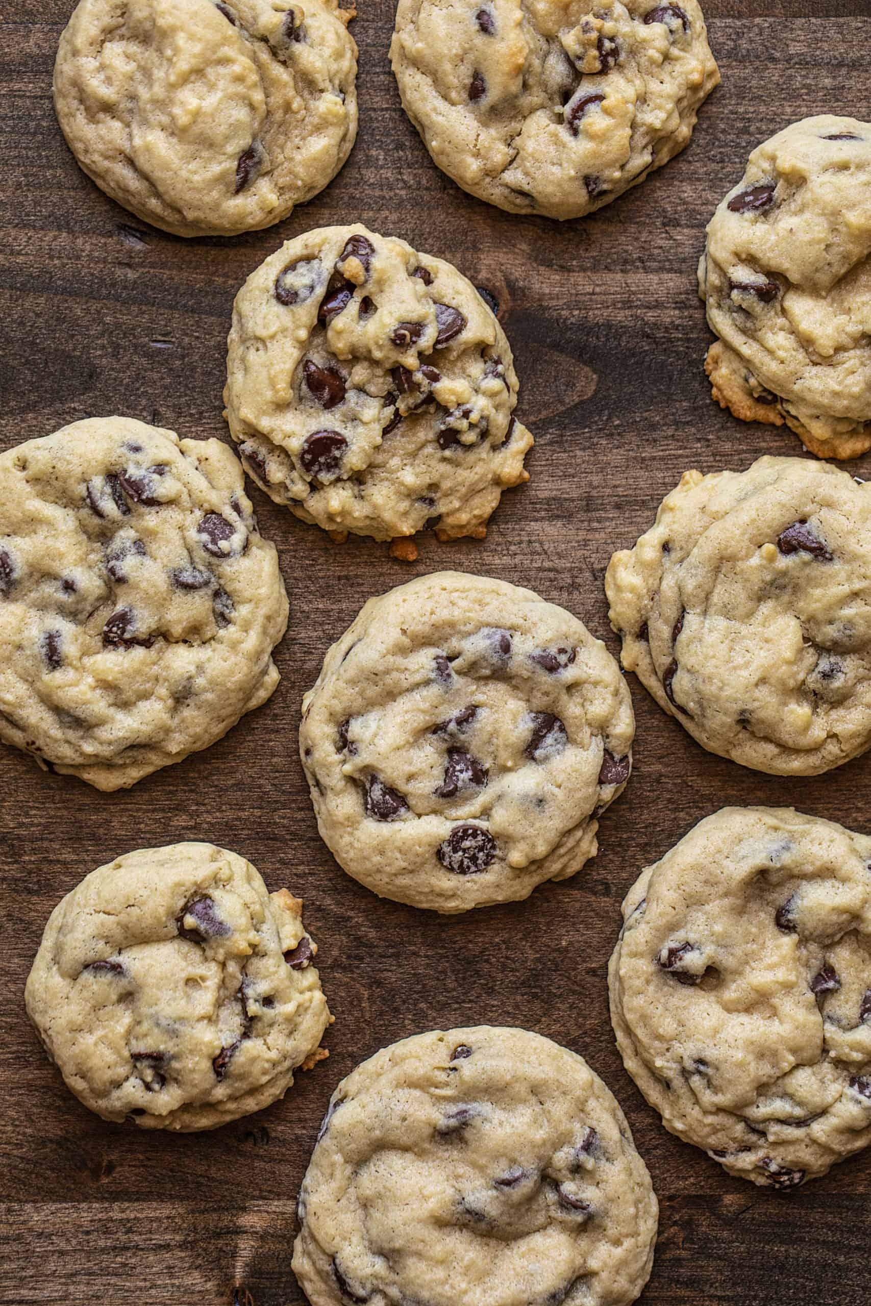 Use your sourdough starter discard to make these Sourdough Chocolate Chip Cookies as cake-like or as chewy as you prefer! sourdough chocolate chip cookies, chocolate chip cookies recipe, sourdough starter, how to make sourdough chocolate chip cookies, iambaker, i am baker, cookies, desserts Overhead of Sourdough Chocolate Chip Cookies on Wood Surface