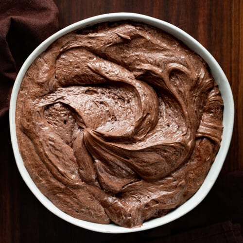 Bowl of Chocolate Ermine Frosting on Dark Cutting Board.