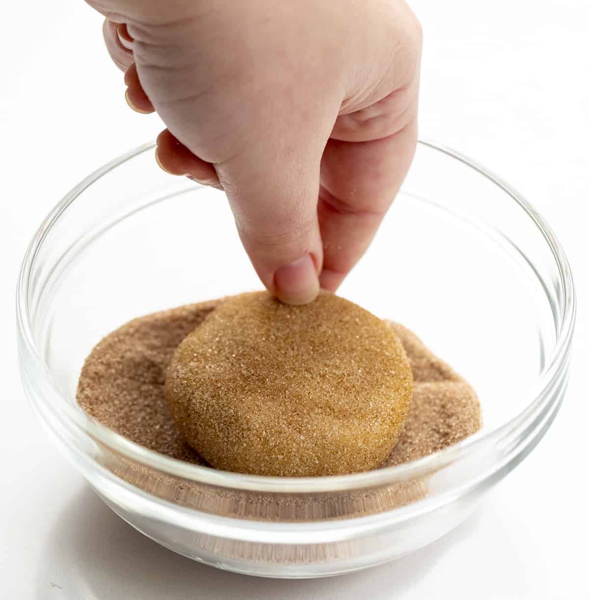 Hand Dipping Cookie Dough into Cinnamon Sugar for Churro Cookie