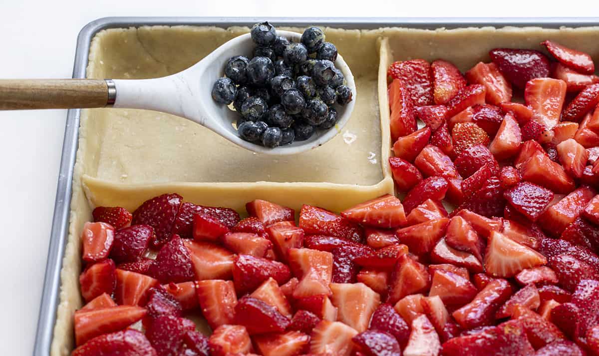 Adding Blueberries to the Corner of an Unbaked Stars and Stripes Pie - Flag Pie.