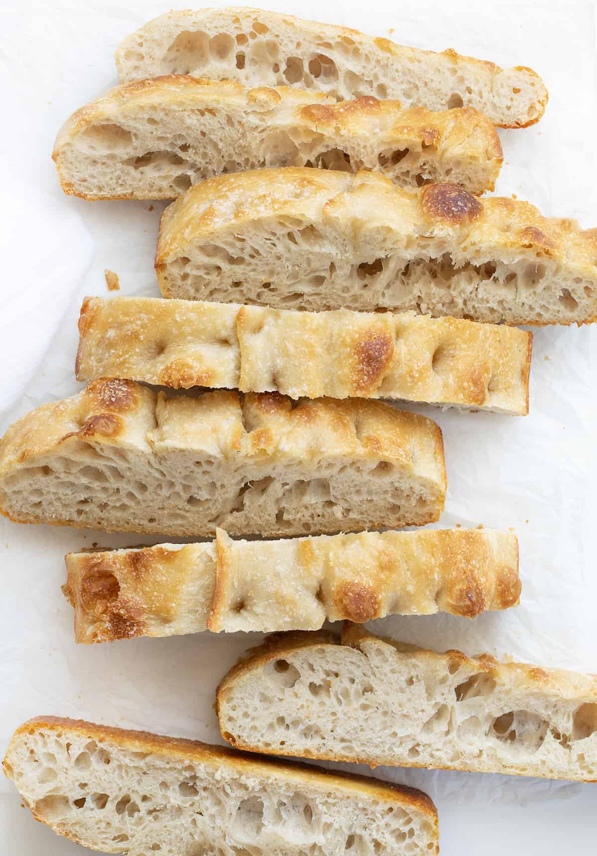 Cut up Pieces of Sourdough Focaccia on a White Cutting Board.