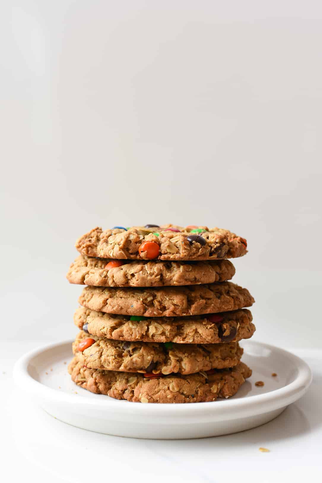 Giant Monster Cookies stacked on White Plate