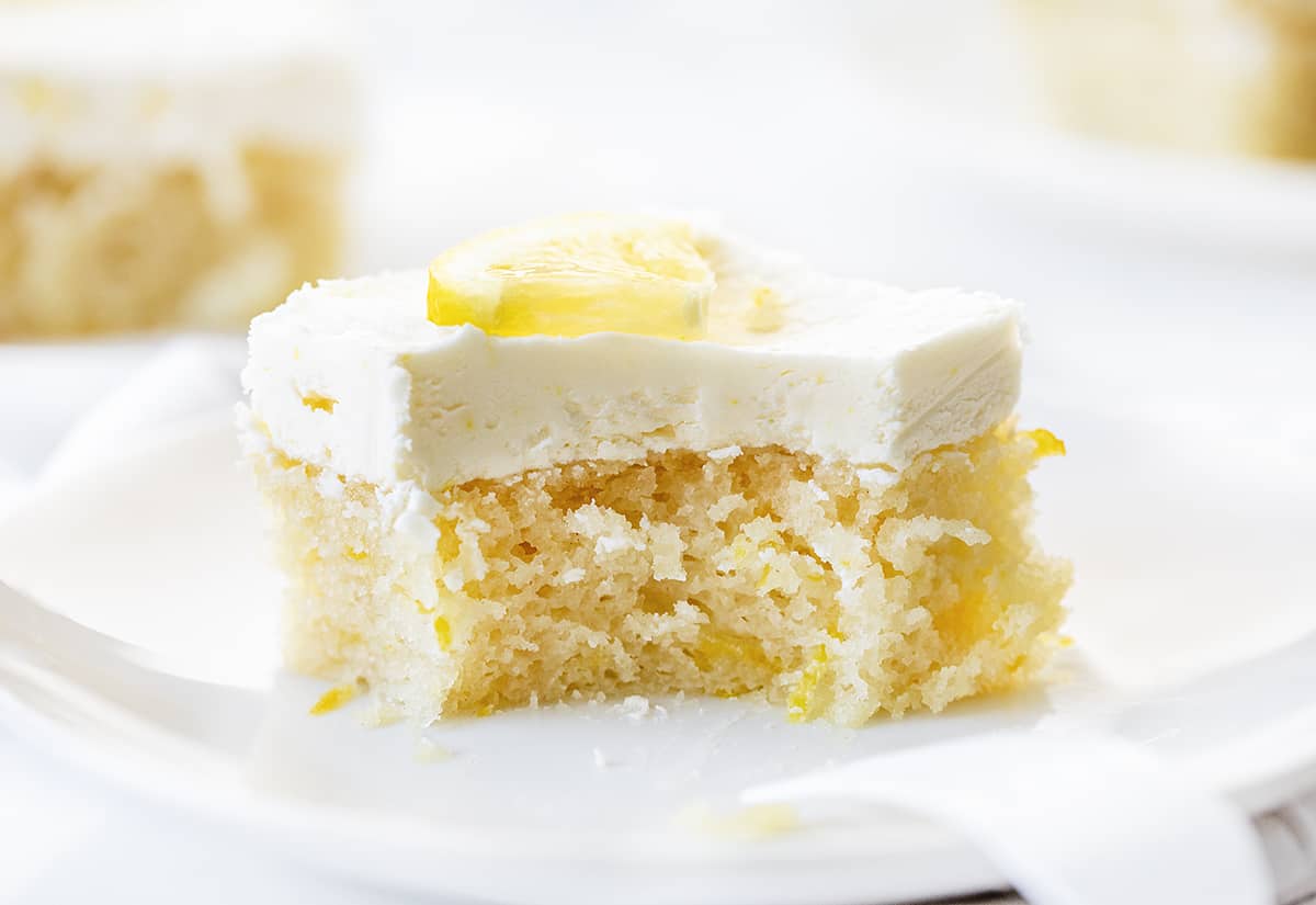 Piece of Lemon Crazy Cake with a Bite Taken Out and Fork Resting on Plate.