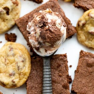 Scoop of Cookie Dough Brownie Ice Cream on Top of Brownies and Cookie Dough.