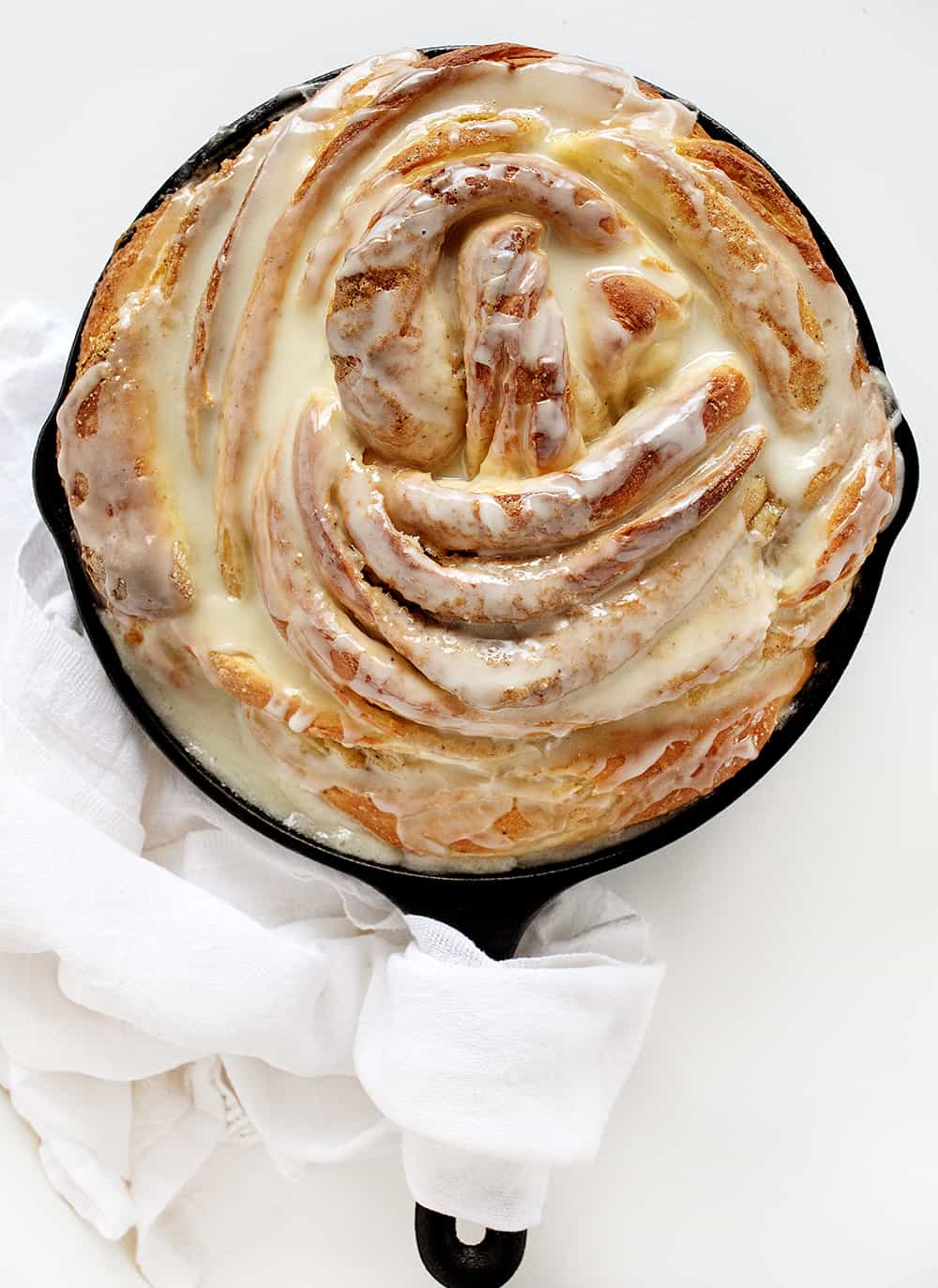 Orange Cardamom Breakfast Bread Twist in a Skillet on a White Surface.