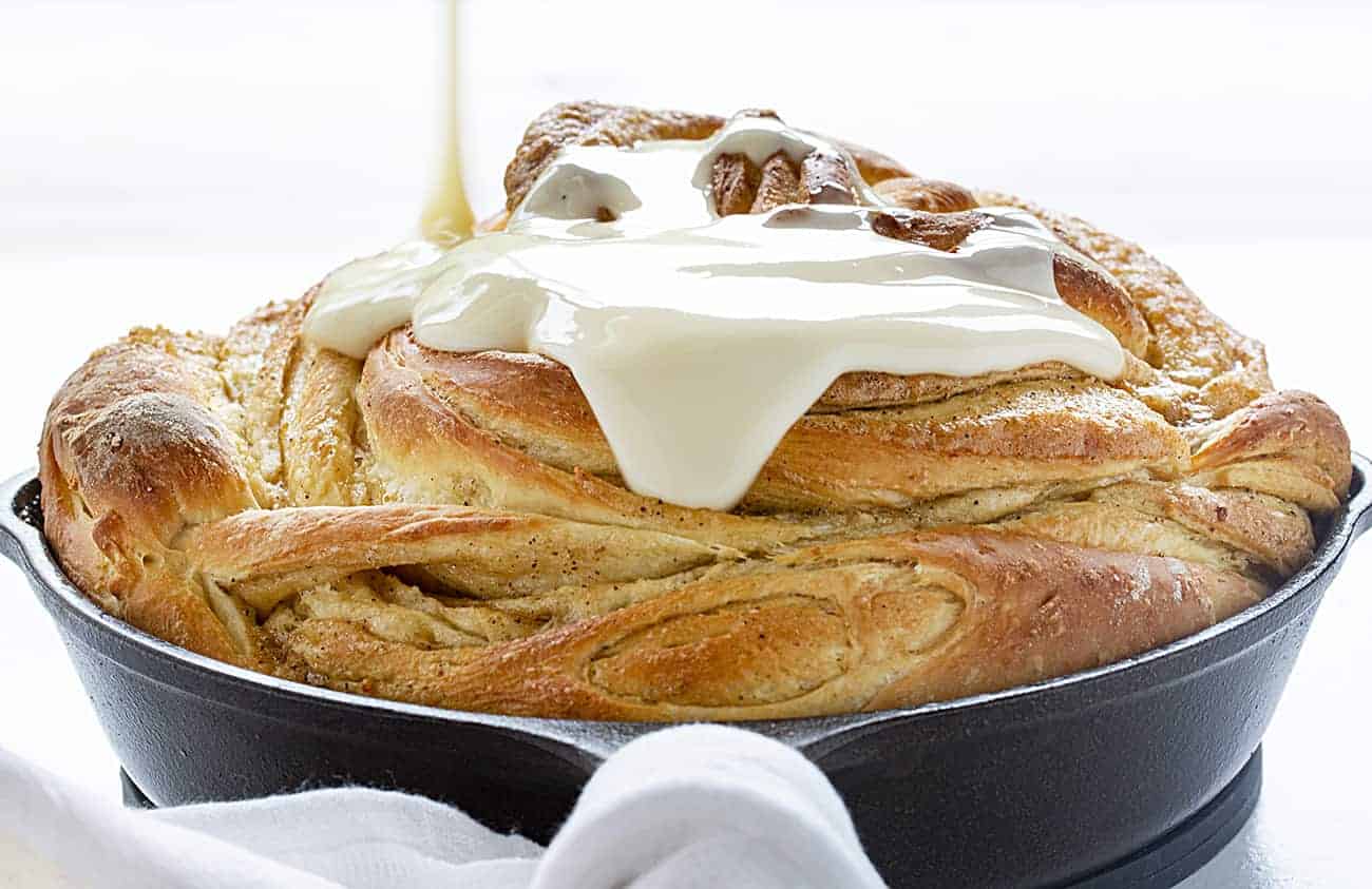 Pouring Glaze over Orange Cardamom Breakfast Bread Twist