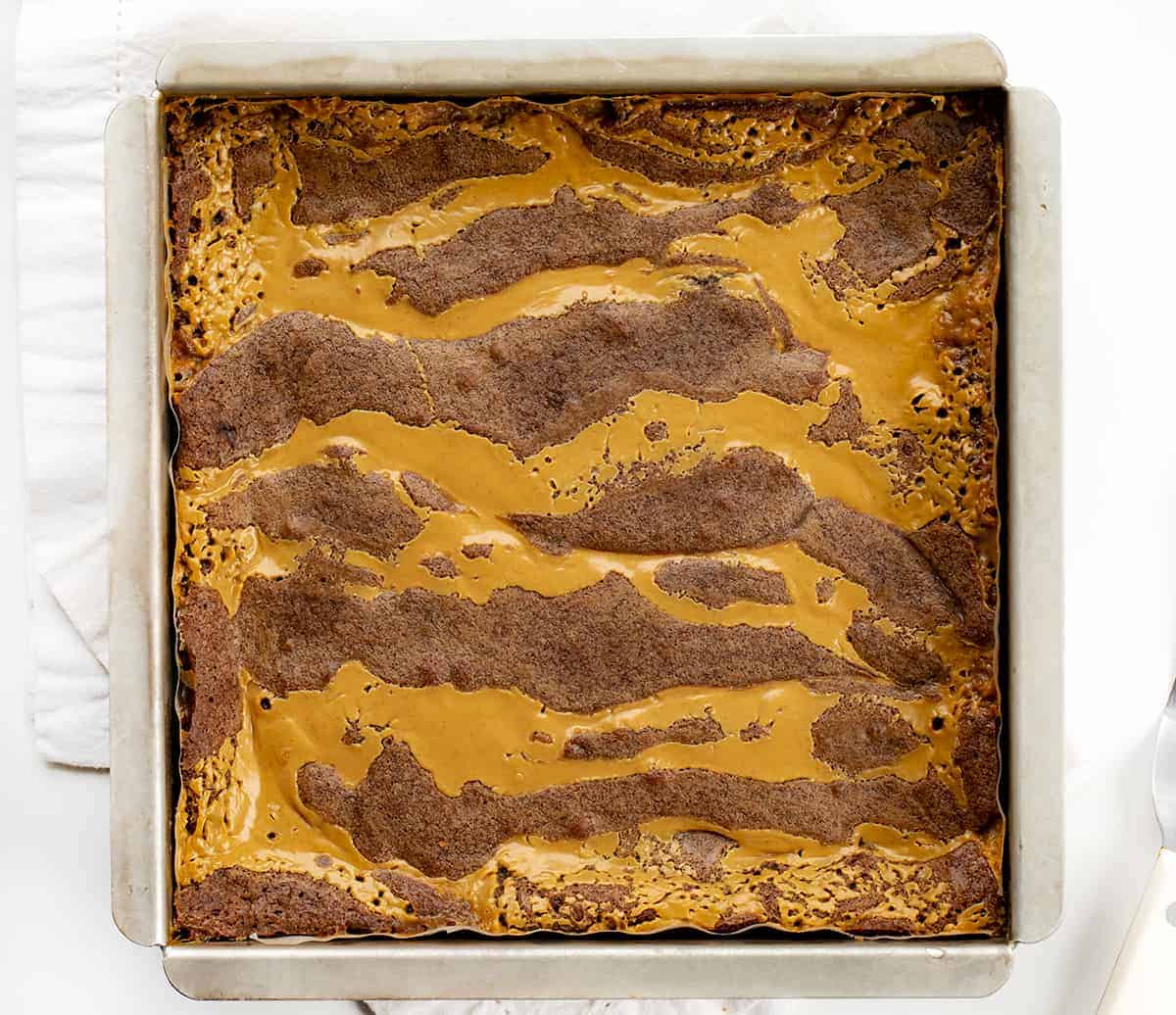 Peanut Butter Brownie Caramelitas are the ULTIMATE ooey gooey brownie! They have a sweet caramel center, along with a layer of peanut butter morsels with more peanut butter drizzled on top. Baking, Brownies, Brownie Recipe, Dessert, Peanut Butter Dessert, Caramel Dessert, dessert recipes, decadent desserts, ooey gooey desserts, i am baker, iambaker Overhead Image of Peanut Butter Brownie Carmelitas in a Baking Dish