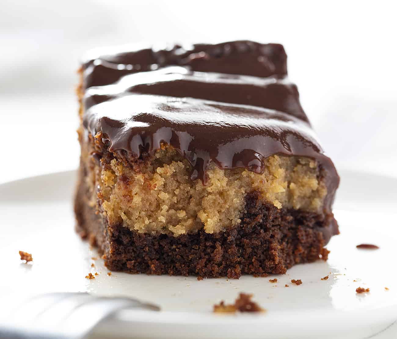 Chocolate Peanut Butter Ooey Gooey Cake with Fork Resting on White Plate