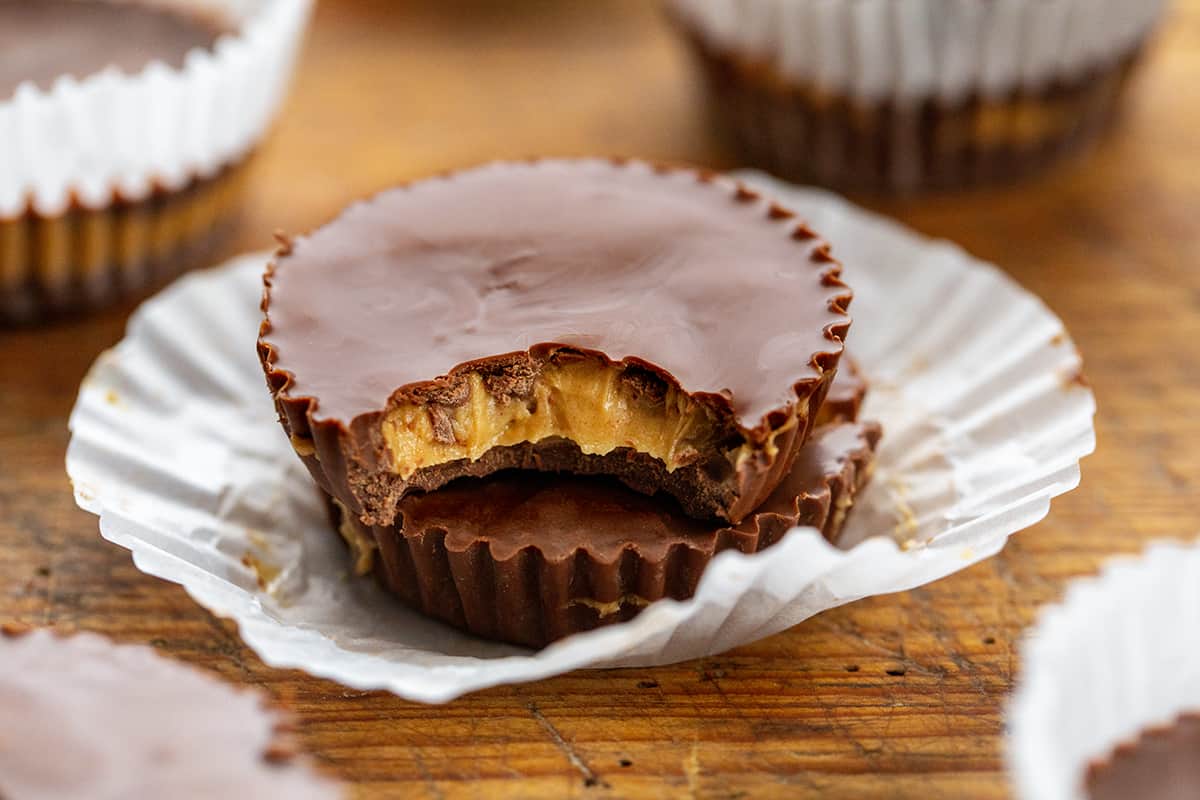 Two Homemade Peanut Butter Cups Stacked and Top One with a Bite Taken Out of It. 