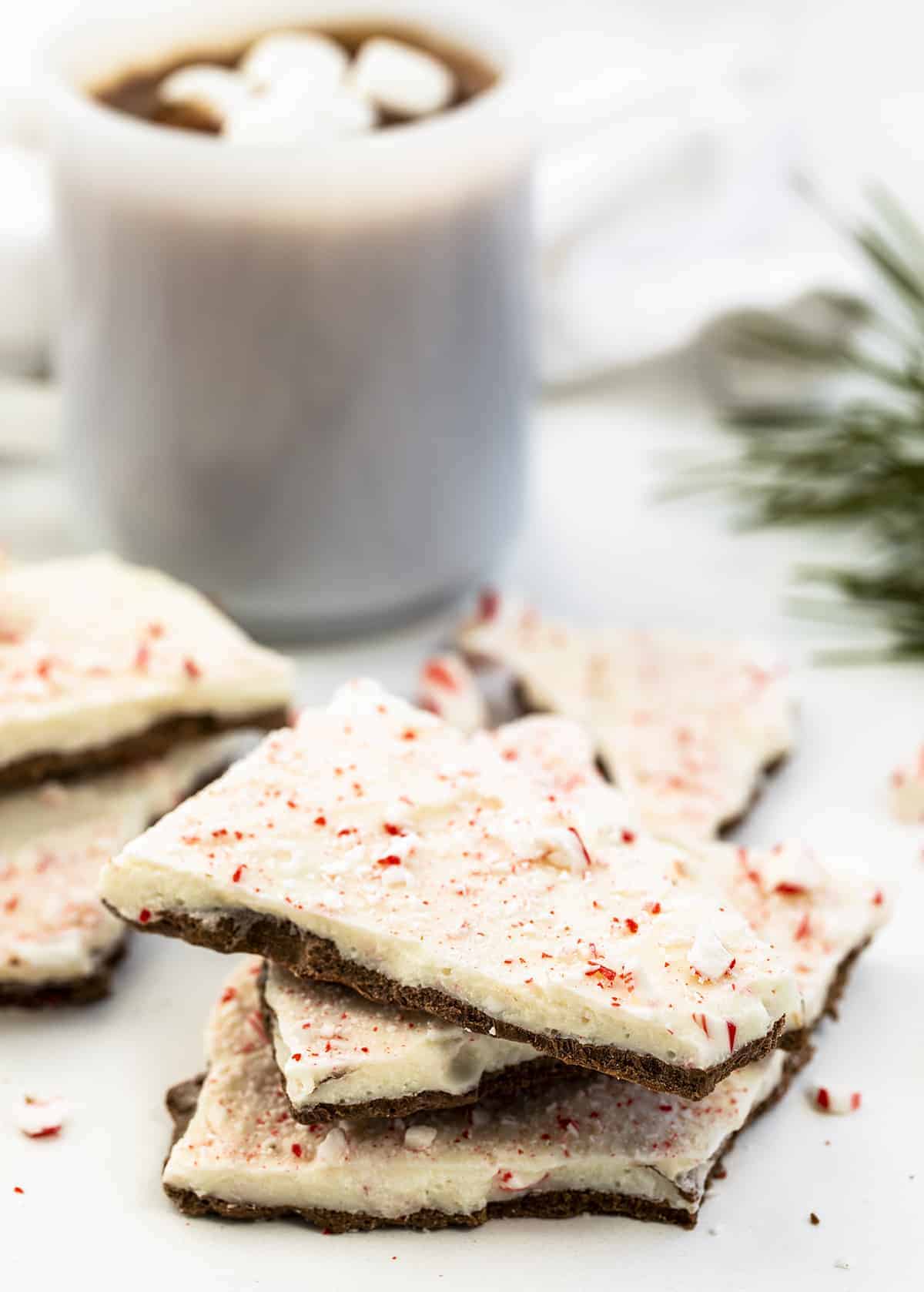 Peppermint Bark is a no-bake candy treat with a milk chocolate peppermint layer topped with a white chocolate peppermint candy cane mixture with more crushed candy canes on top. Holidays, Chocolate Bark, How to Make Bark, Easy Peppermint Bark. Williams Sonoma Peppermint Bark, Christmas Dessert, No Bake Dessert, New Years Ever Dessert, chocolate, chocolate recipes, i am baker, iambaker Peppermint Bark Broken and Stacked with Hot Cocoa