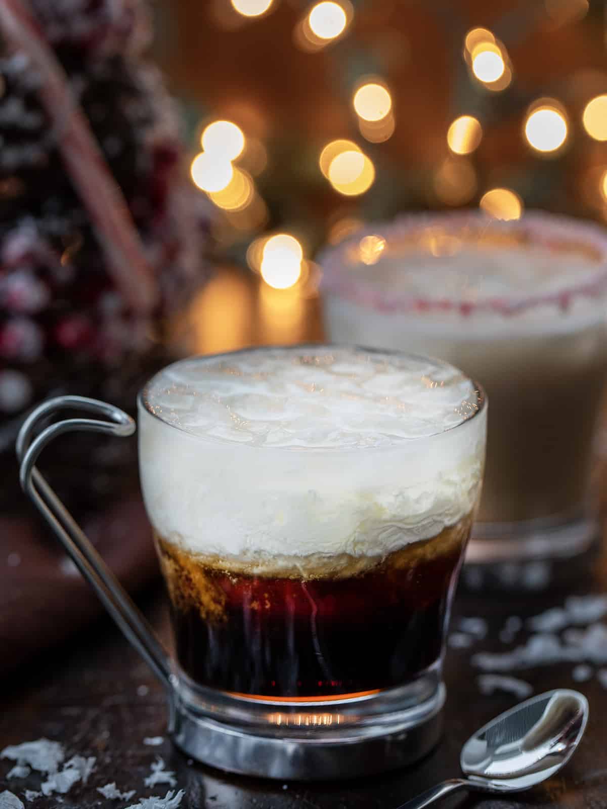 Peppermint White Russians in front of a Christmas Tree and Twinkling Lights.