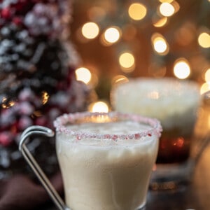 Peppermint White Russians in front of a Christmas Tree and Twinkling Lights.