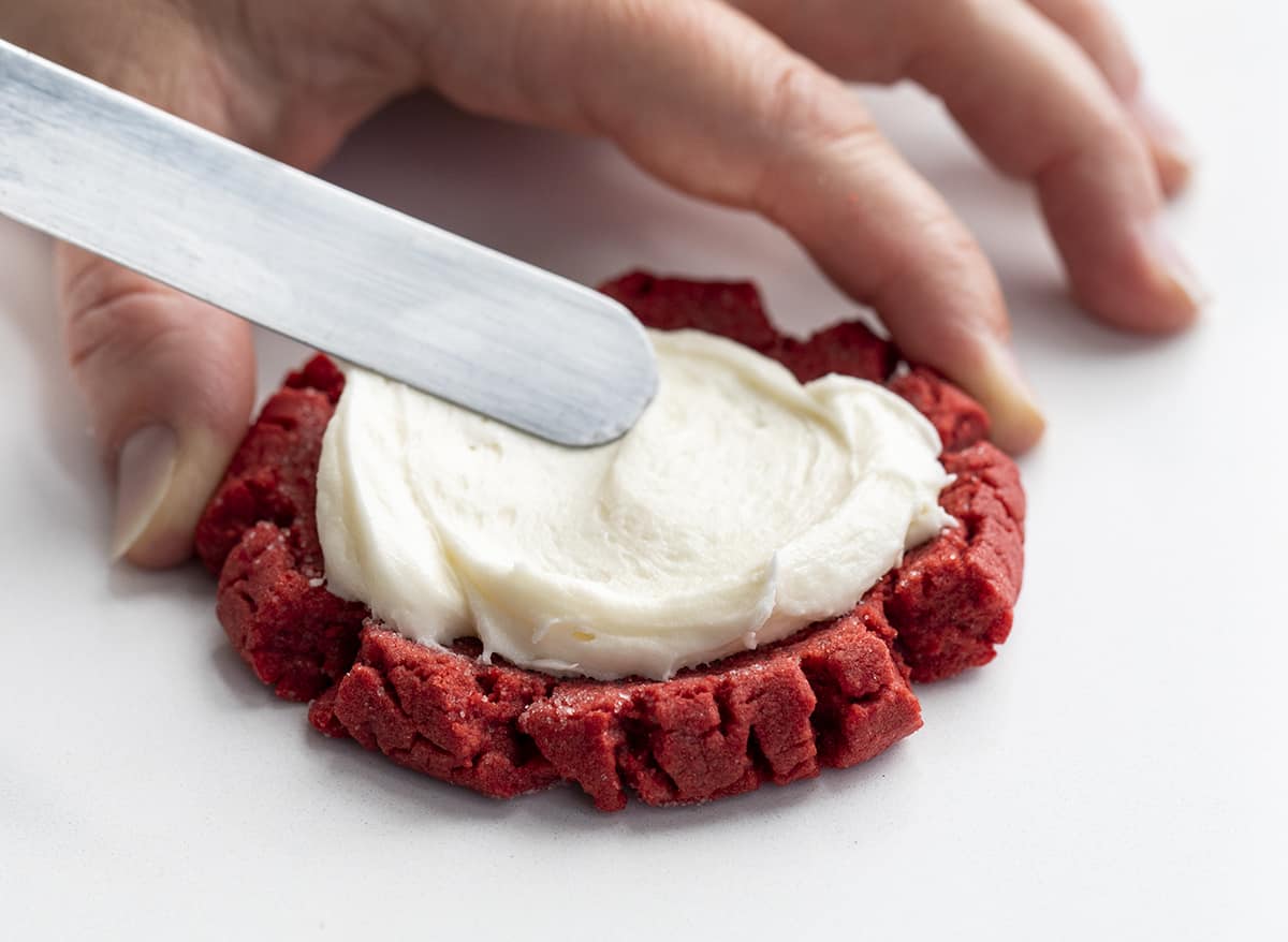 Swirling Cream Cheese Frosting onto a Red Velvet Cookie to Make Red Velvet Cream Cheese Cookies. Dessert, Cookies, Baking, Christmas Cookies, Holiday Baking, Cookie Exchange, Red Velvet Recipes, Red Velvet Cookies, Cream Cheese Frosting, Frosted Sugar Cookies, i am baker, iambaker