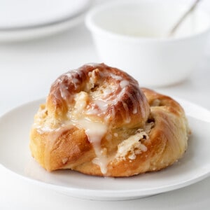 Ring A Ling Pastry on a White Plate with Glaze in the Back.