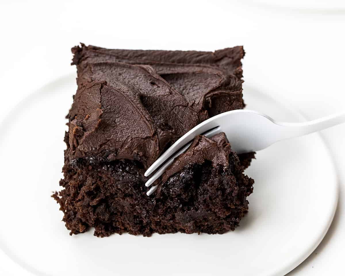 Fork Taking a Bite Out of One Piece of Chocolate Sauerkraut Cake on a White plate. 