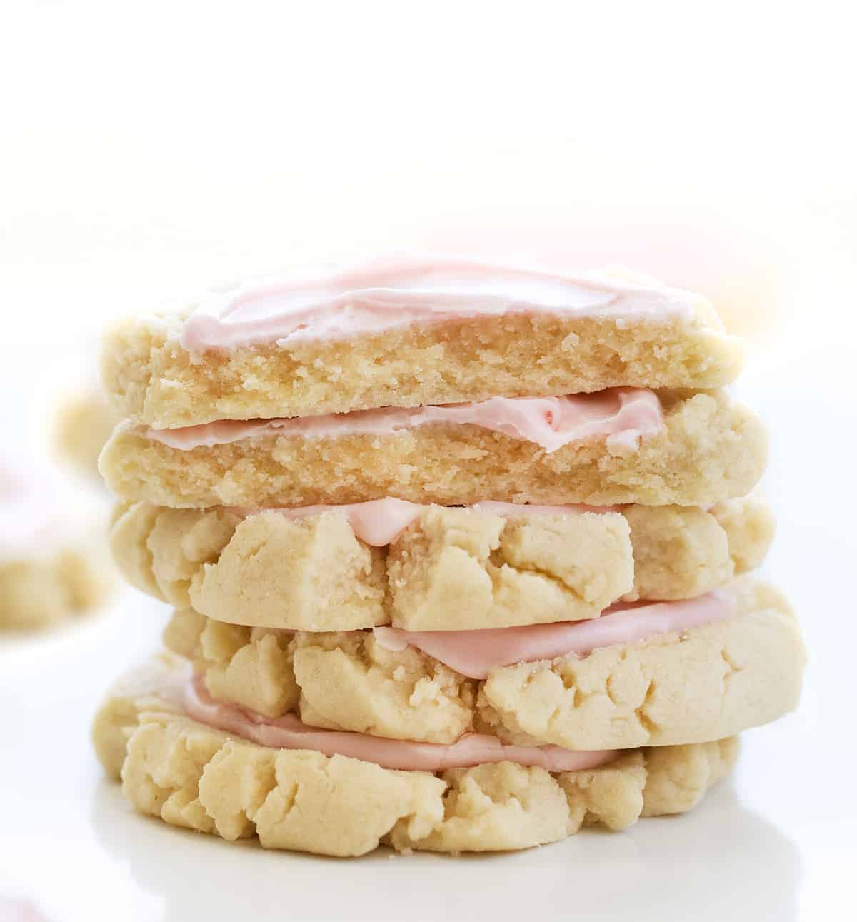 Stack of Copycat Swig Frosted Sugar Cookies with Top Cookies Broken in Half Showing Inside. Dessert, Cookies, Cookie Recipes, Swig Copycat, Baking, Cookie Exchange, Frosted Cookies, iambaker cookie recipes, the best sugar cookies, sugar cookie, i am baker, iambaker