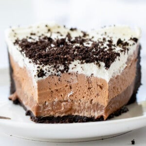 Piece of Triple Chocolate Mousse Pie on a White Plate with Some Removed Showing Texture.