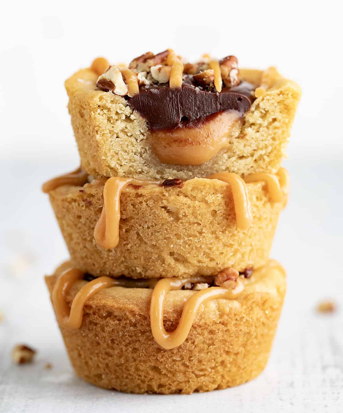 Stacked Turtle Cookie Cups with the Top Cup Cut in Half Showing Inside.