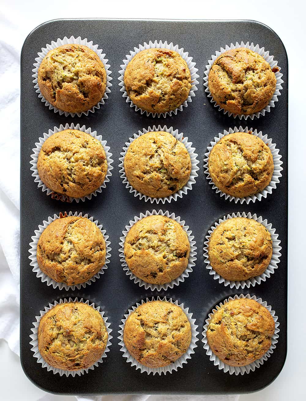 Banana Zucchini Muffins are so moist and delicious, you will never think of buying a muffin again! banana zucchini muffins, zucchini muffins, banana muffins, homemade muffins, iambaker, baking, muffins, bananas, zucchini recipes Pan of Baked Banana Zucchini Muffins From Overhead.
